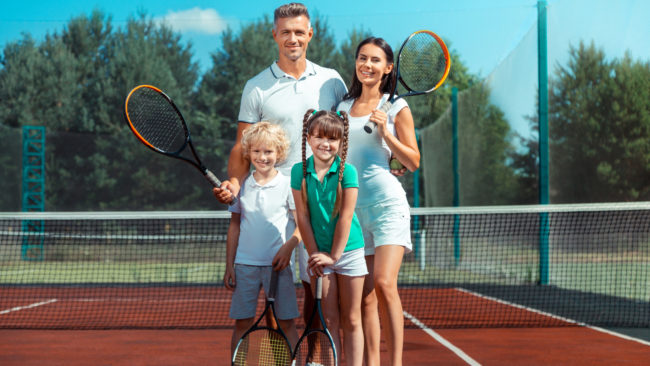 Parents and children feeling happy and cheerful after playing tennis